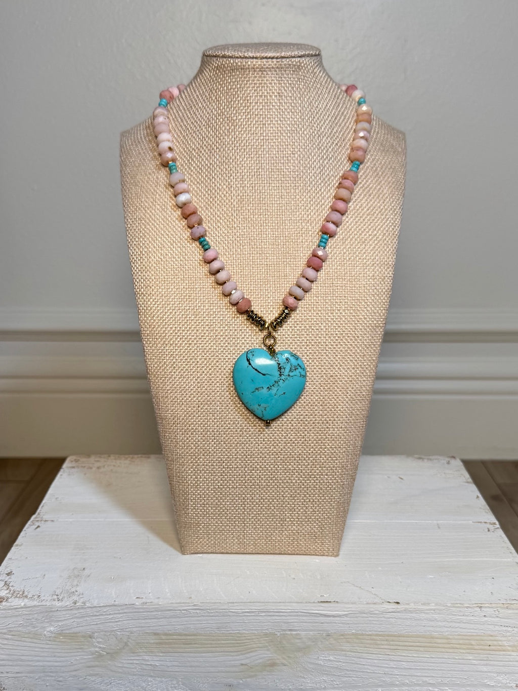Pink opal and turquoise heart necklace displayed on a bust