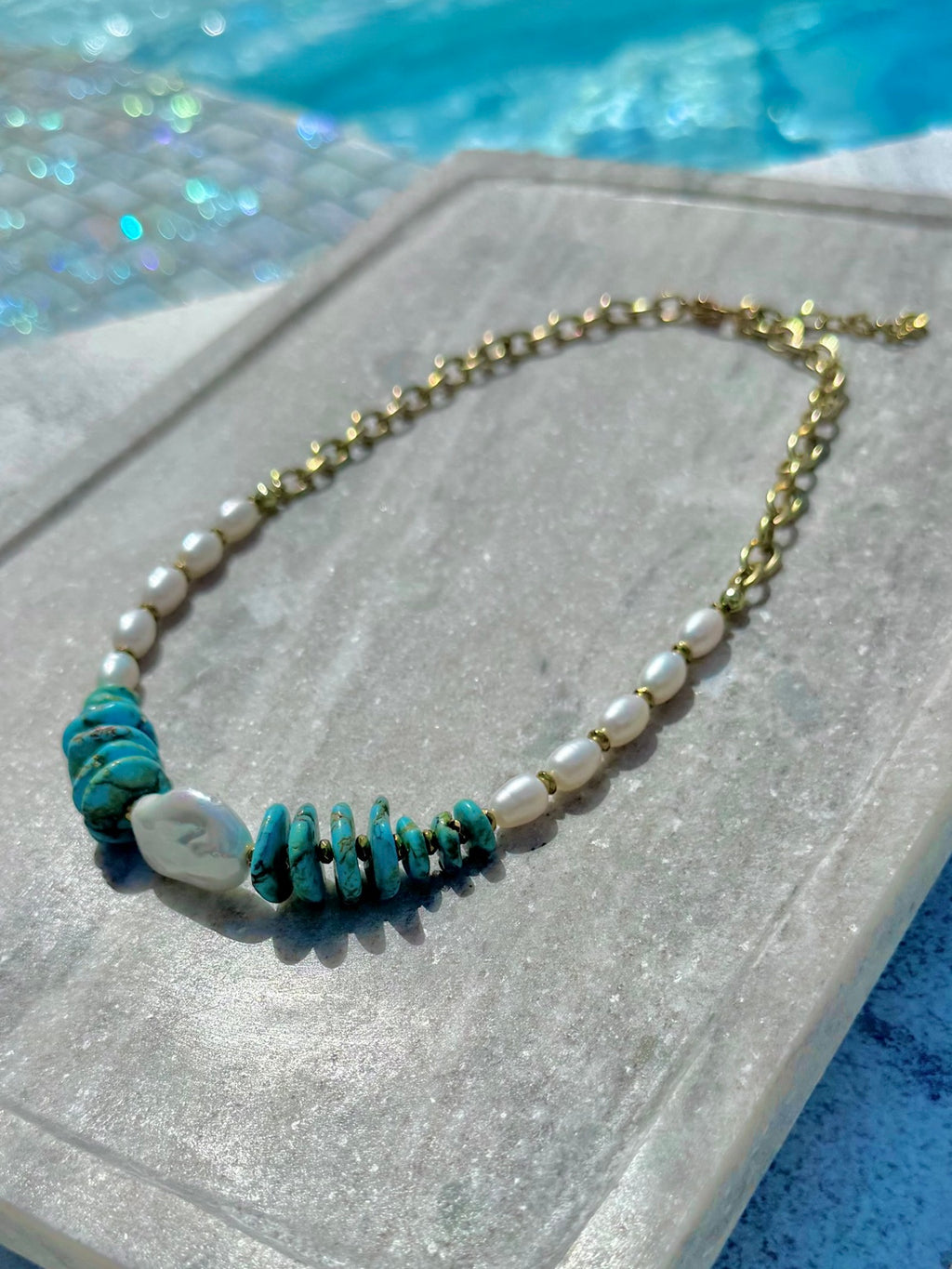 Angled poolside view of dyed howlite and freshwater pearl necklace