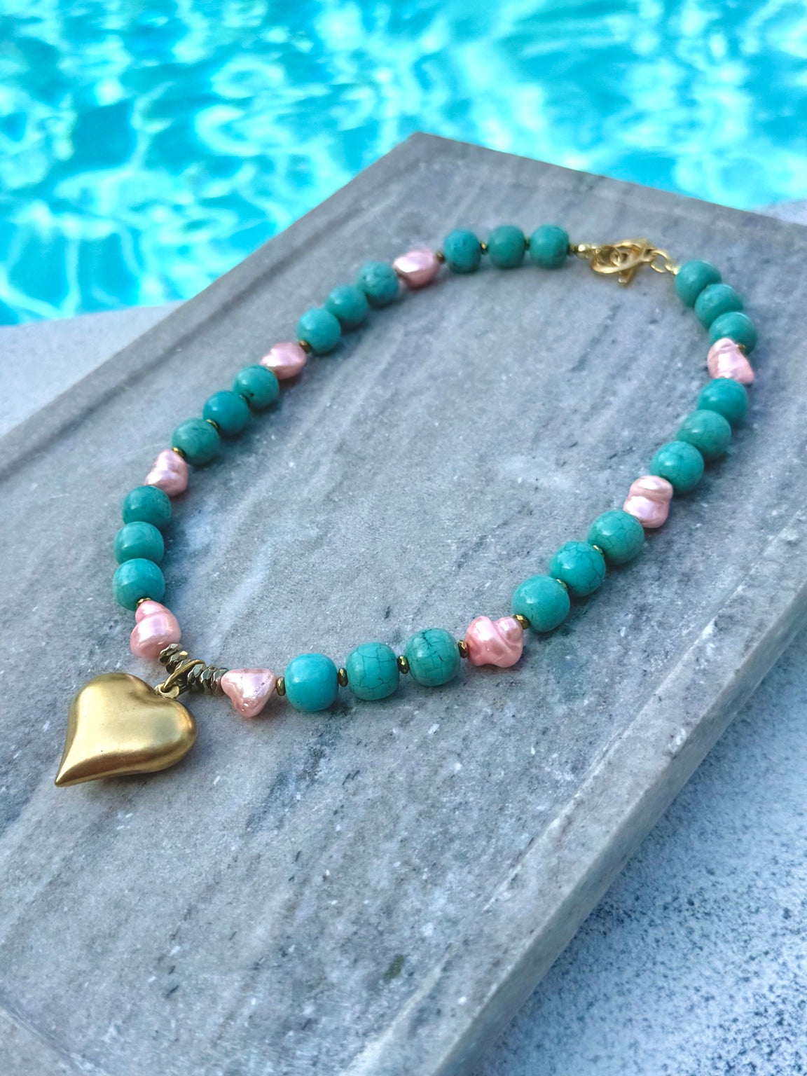 Alternate poolside view of turquoise and pink pearl heart necklace