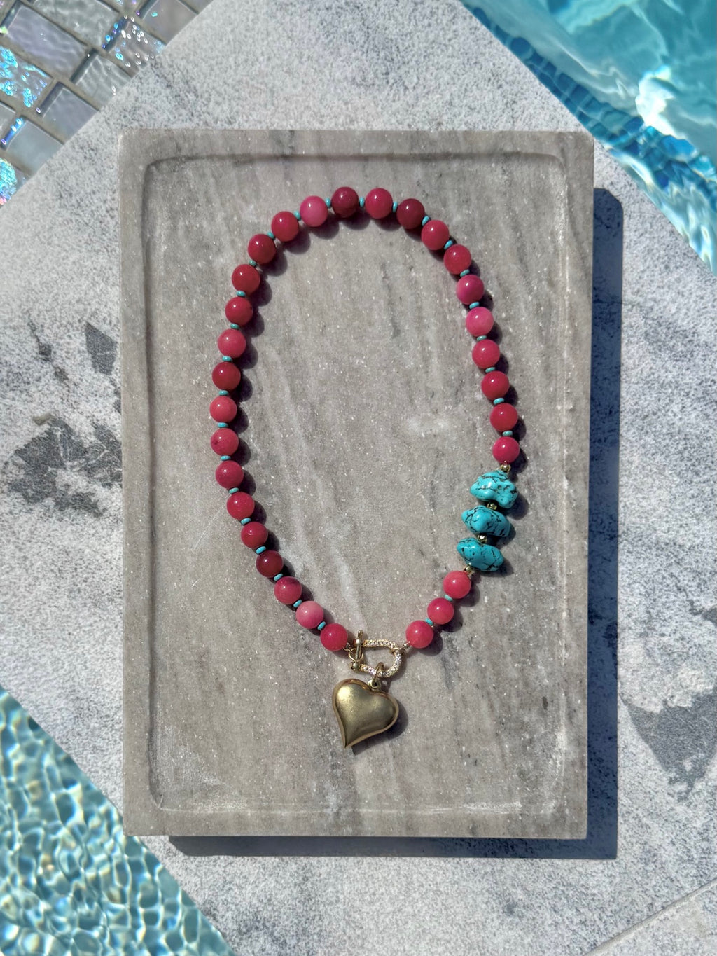 Full view of pink bead necklace with turquoise nuggets and gold heart charm