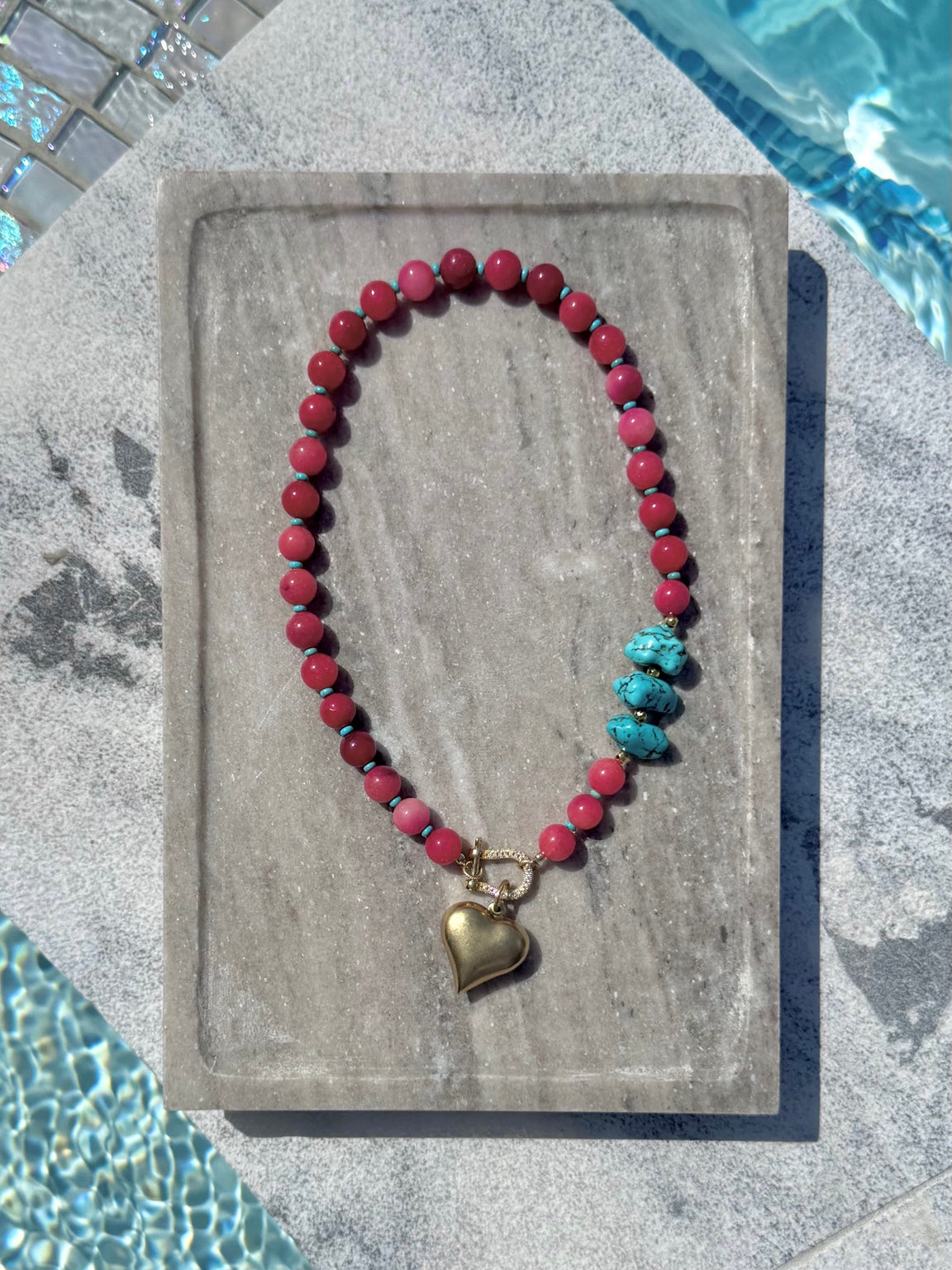 Full view of pink bead necklace with turquoise nuggets and gold heart charm