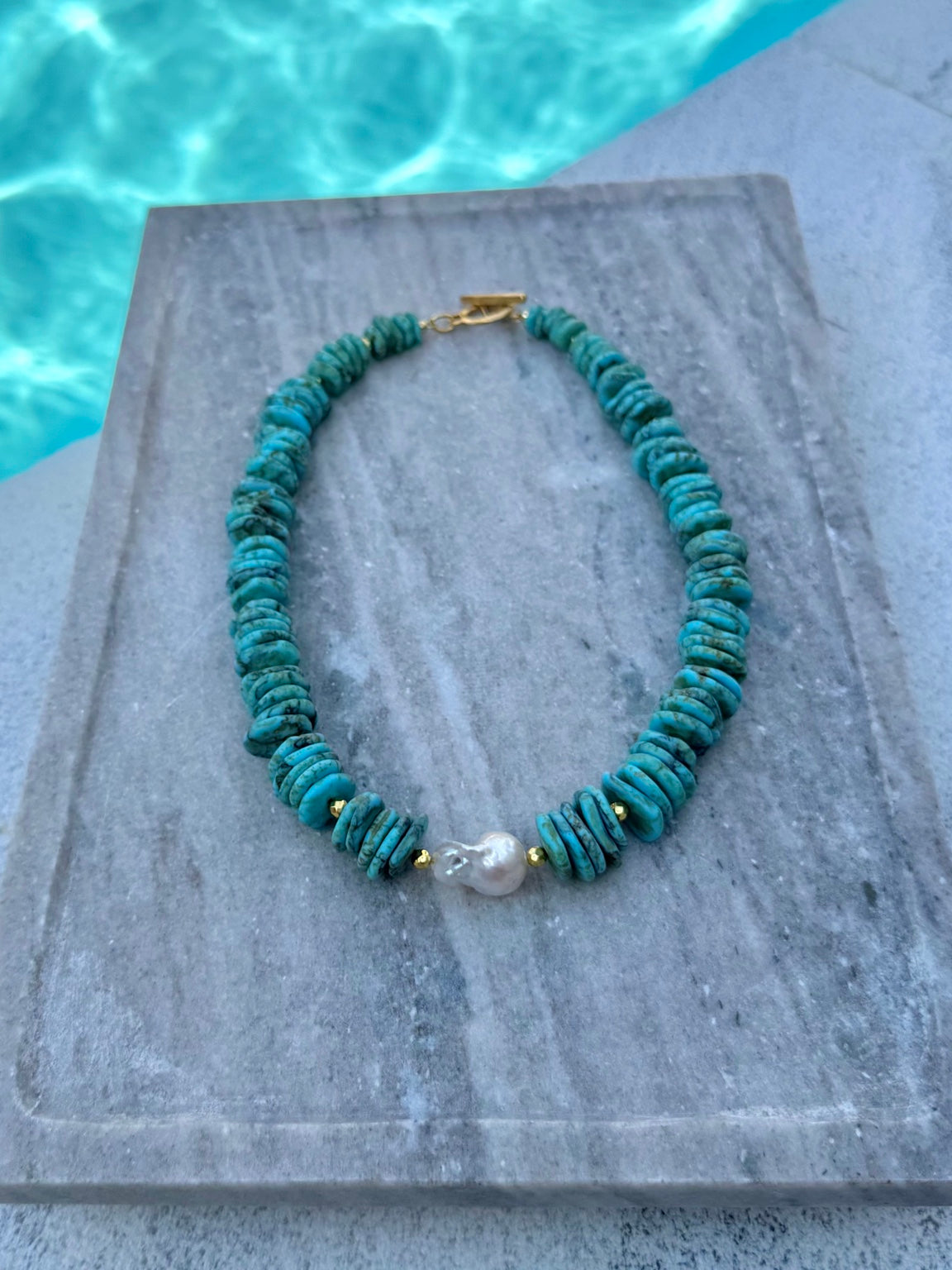The Mackenzie dyed howlite and baroque pearl necklace photographed poolside