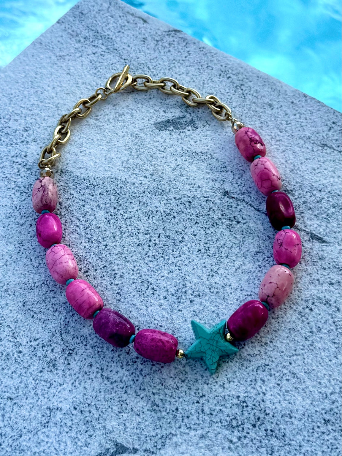 Pink turquoise barrel necklace with turquoise star photographed poolside