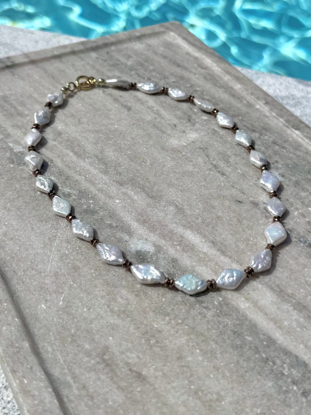 Freshwater pearl and hematite necklace photographed poolside